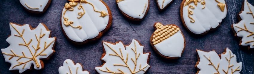 Assorted autumn-themed cookies with white and gold icing.