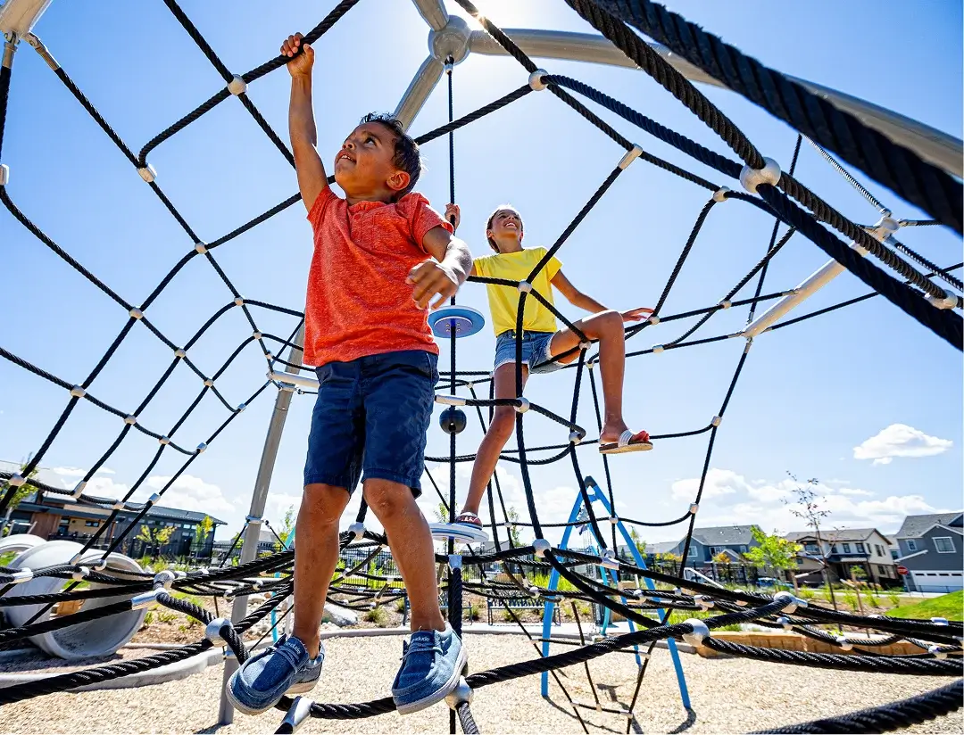 Children climbing on playground equipment at Solstice community park