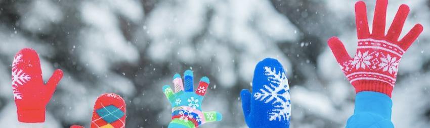 Colorful mittens waving in falling snow.