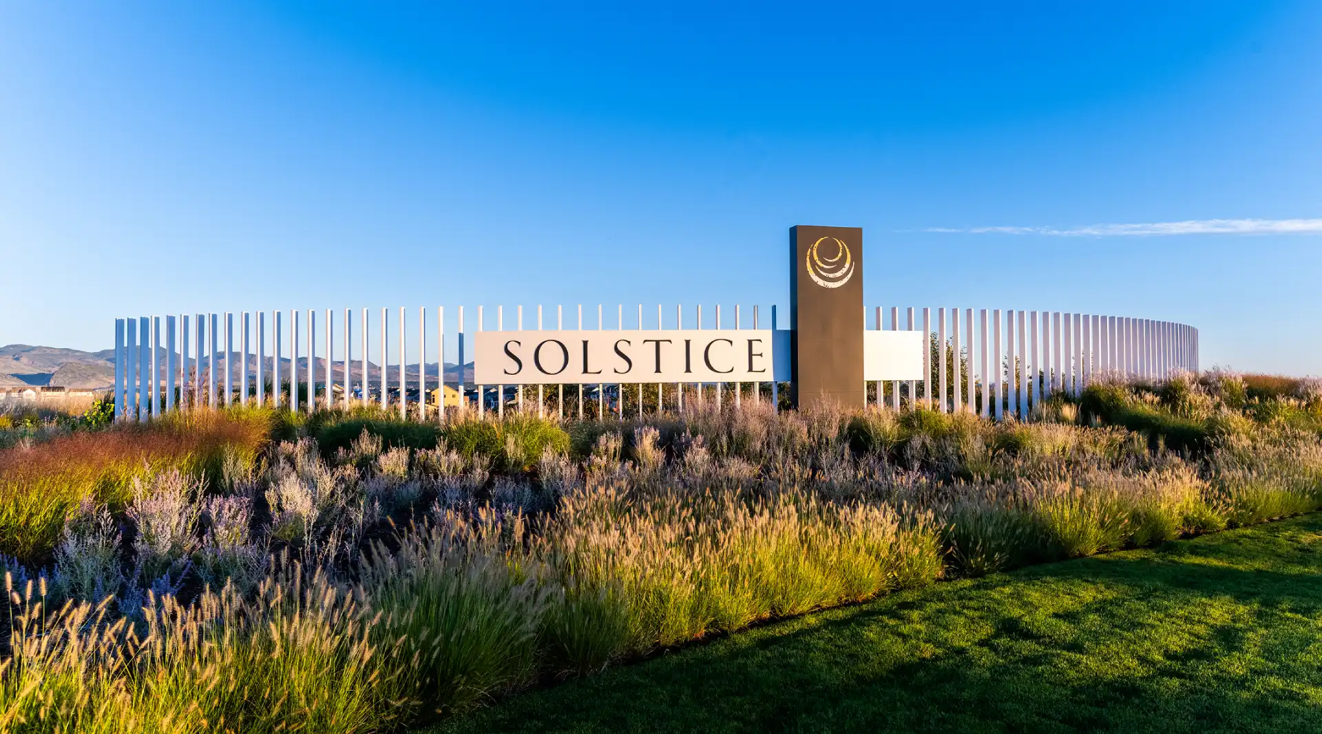 Solstice community entrance sign with landscaped native grasses and mountain views