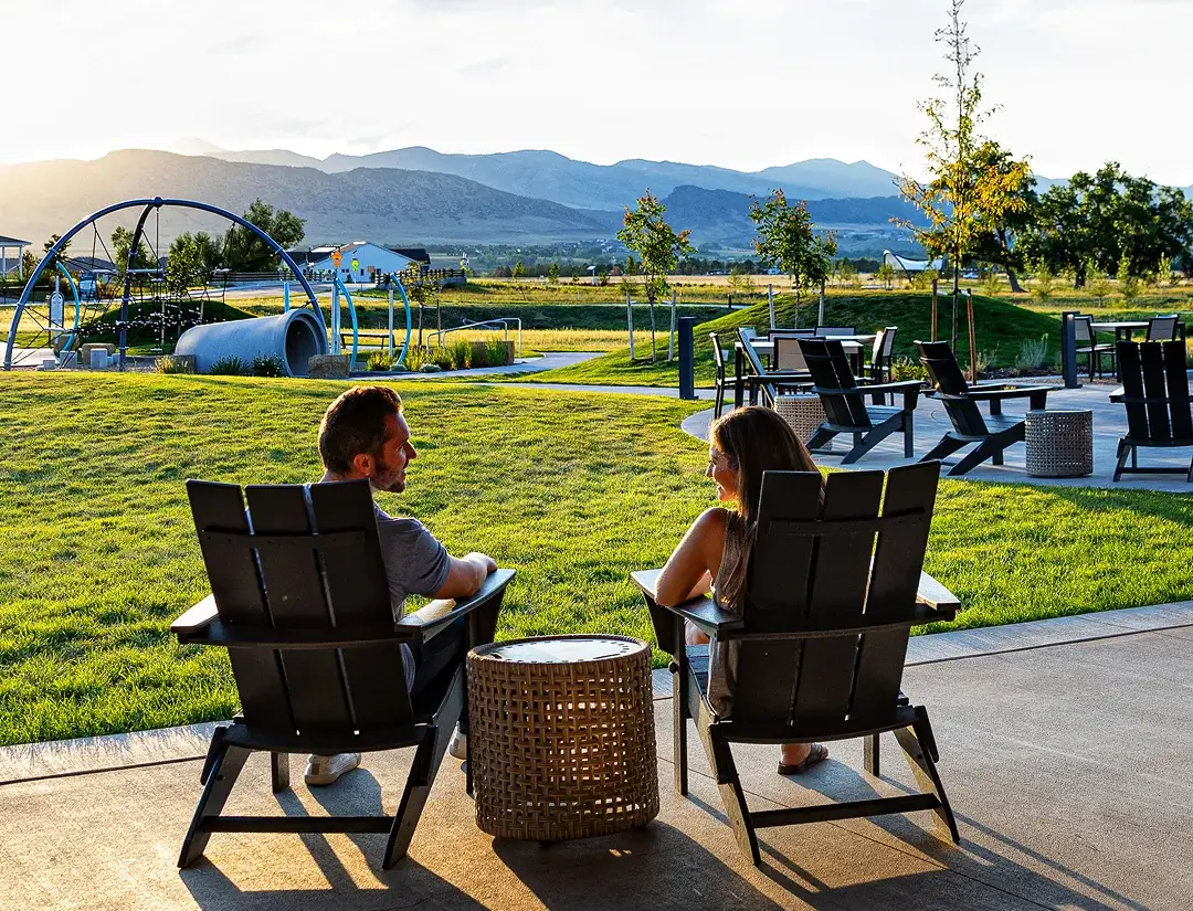 Residents relaxing in outdoor lounge seating with mountain views at Solstice community
