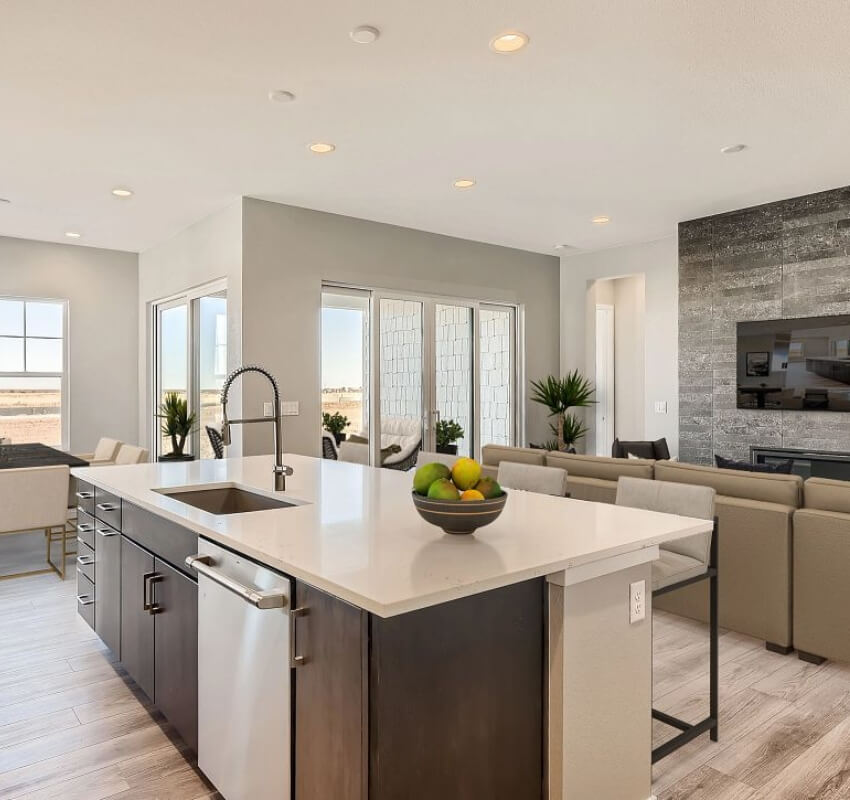 Modern kitchen with island overlooking cozy living room.