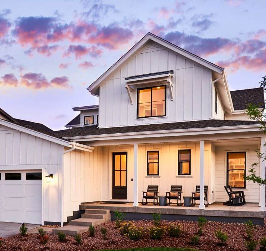 Modern house at sunset with porch seating.