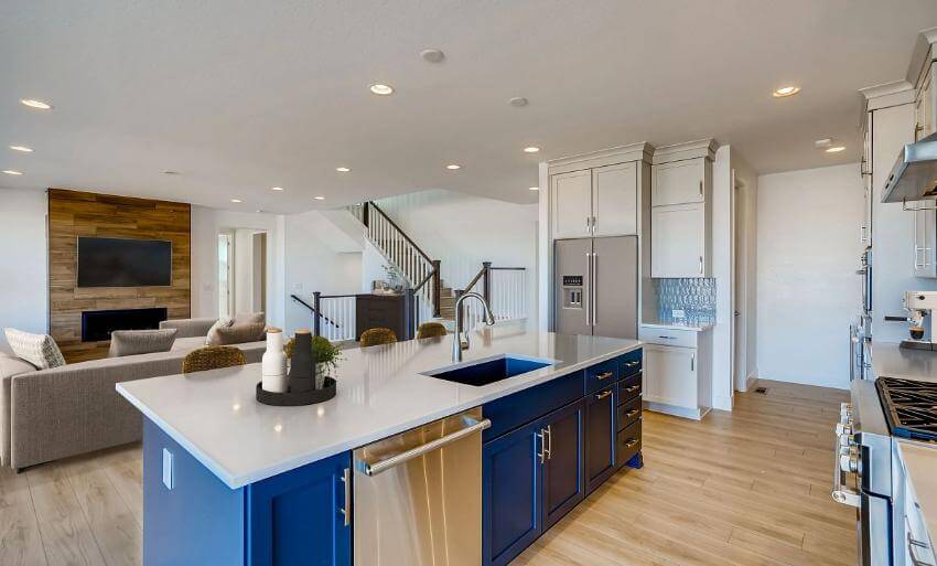 Modern kitchen with island, living area in background.