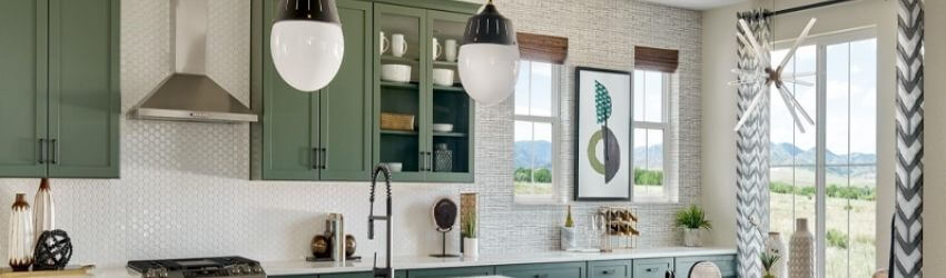 Modern kitchen with green cabinets and large windows.