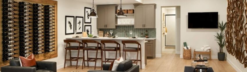 Modern kitchen with bar stools and wall-mounted wine rack.