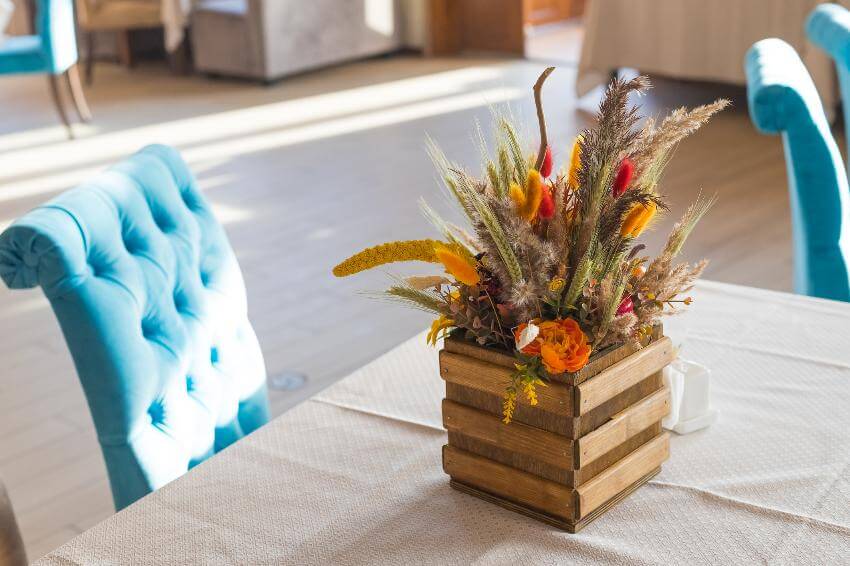 Floral arrangement in vase on sunlit table.