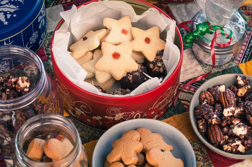 Festive cookies arranged in colorful tins and bowls.