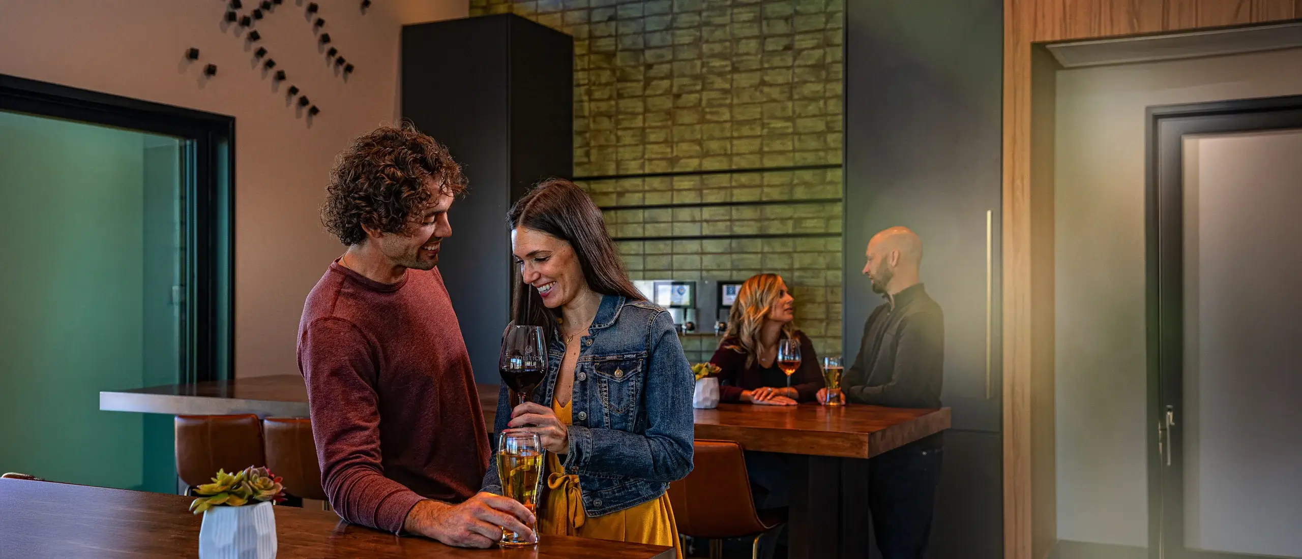 Couple enjoying drinks in a modern kitchen.