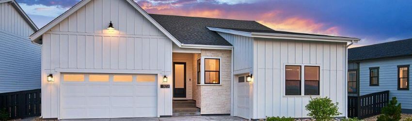 Modern house at sunset with lit exterior lights.