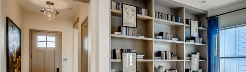 Hallway with bookshelves and decorative art displayed neatly.